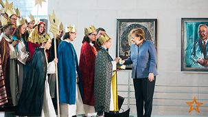 Bundeskanzlerin Angela Merkel spendet für Sternsinger.