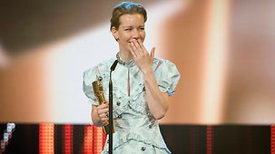 Sandra Hüller steht bei der Verleihung des Deutschen Filmpreises mit ihrem Preis auf der Bühne.