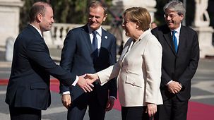 Chancellor Angela Merkel is welcomed by Malta's Prime Minister Joseph Muscat, President of the Council of the European Union.