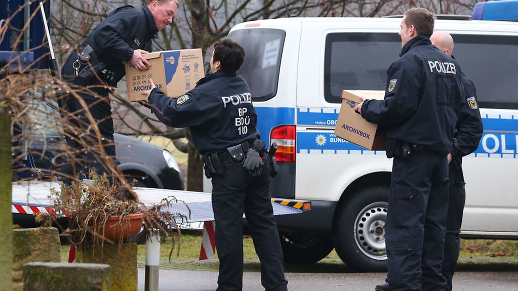 Beamte der Bundespolizei verladen Unterlagen in einen LKW.