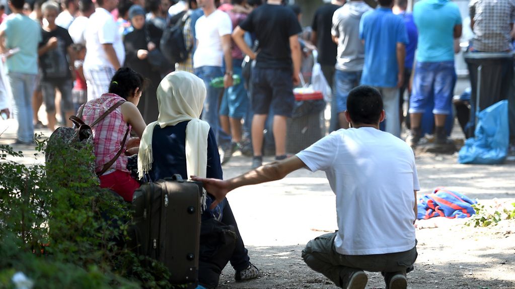 Flüchtlinge warten auf dem Gelände des Landesamtes für Gesundheit und Soziales (LaGeSo) in Berlin in der Hitze.