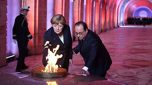Chancellor Angela Merkel and French President François Hollande light the eternal flame.