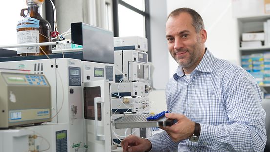 Ein Wissenschaftler füllt einen Hochdruck-Flüssigkeits-Chromatograph mit Proben an der Universität Hohenheim