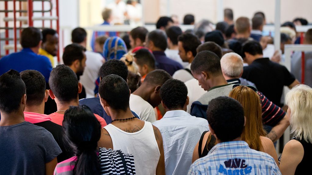 Asylum seekers stand at the entrance to the canteen in the central reception centre for asylum seekers (ZAE) in Zirndorf (Bavaria) on 17.07.2014