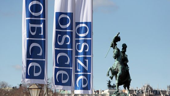 Drei Fahnen mit OSZE-Schriftzug