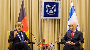 Chancellor Angela Merkel talks to Israel's President Shimon Peres.