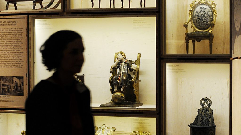 Im jüdischen Museum Berlin geht eine Frau durch die Ausstellung über den Kunstraub der Nationalsozialisten
