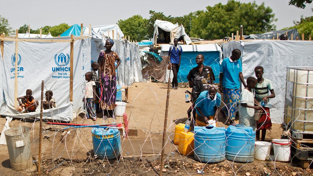 Menschen stehen vor provisorisch errichteten Zelten in einem Flüchtlingslager auf dem Gelaende der VN-Mission UNMISS im Stadtteil Tomping der Hauptstadt Dschuba im Südsudan.