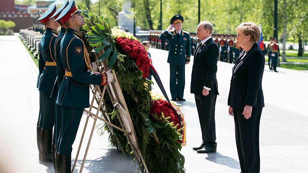 Vladimir Putin and Angela Merkel pay tribute to the victims.
