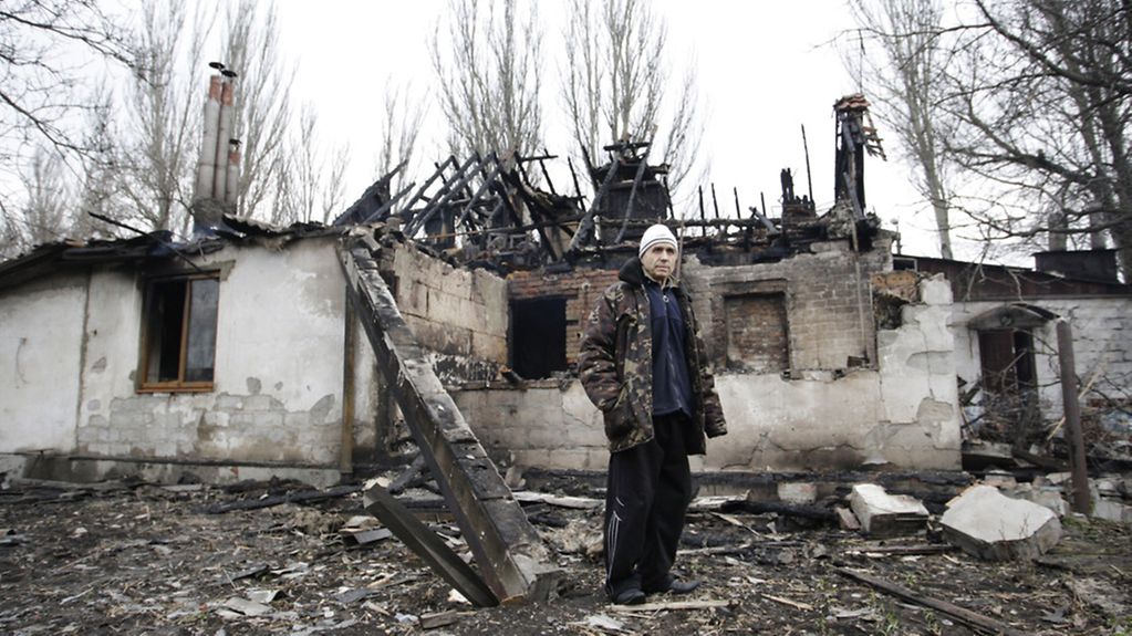 Ein Mann steht vor einem beschädigten Haus im ostukrainischen Donetsk.