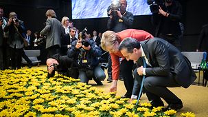 Bundeskanzlerin Angela Merkel und Österreichs Bundeskanzler Christian Kern bewundern die Deko.