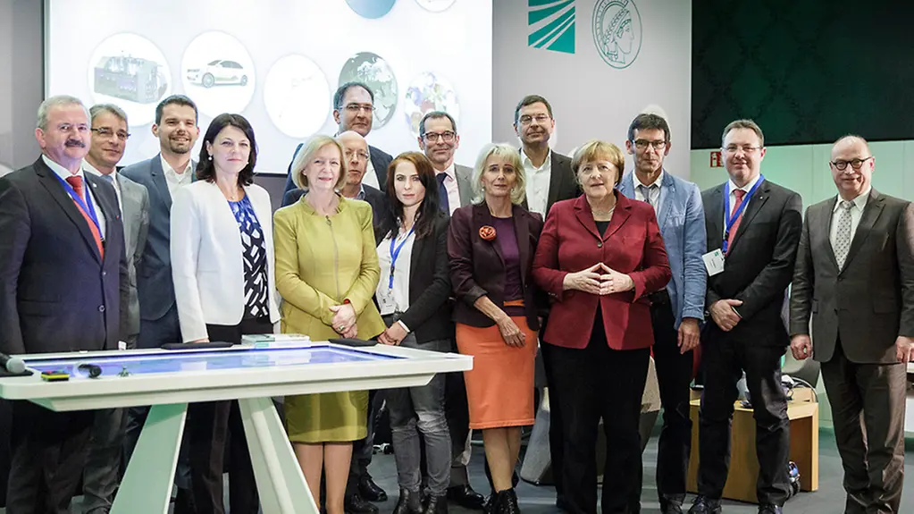Bundeskanzlerin Angela Merkel (1. Reihe, 6.v.l.), Johanna Wanka, Bundesministerin für Bildung und Forschung (1. Reihe, 3.v.l.), und Rainer Sontowski, Staatssekretär im Bundesministerium für Wirtschaft und Energie (2. Reihe, M.), mit Reimund Neugebauer, …