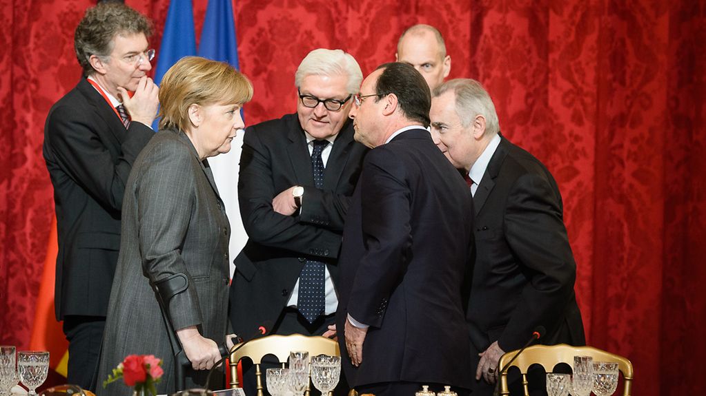 Bundeskanzlerin Angela Merkel unterhält sich mit Außenminister Frank-Walter Steinmeier und dem französischen Präsident François Hollande.
