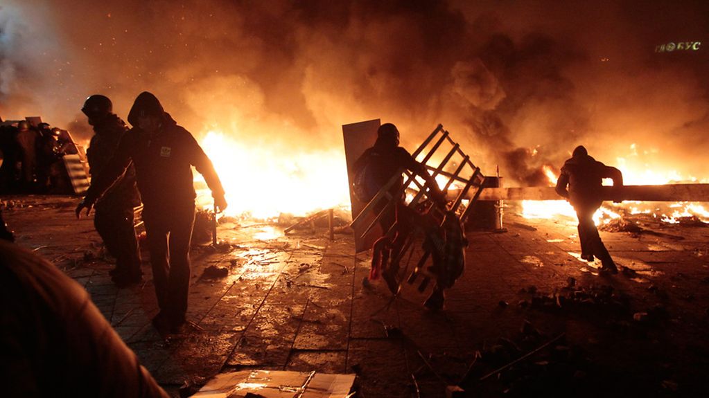 People between burning barricades in Kyiv