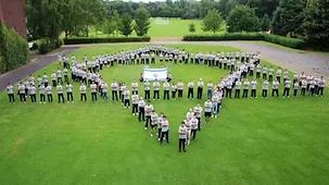 Sportlerinnen und Sportler stellen ein Gruppenfoto in Form des jüdischen Davidssterns.