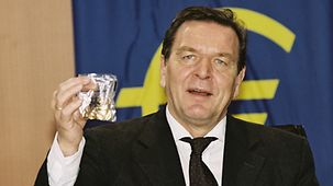 Chancellor Gerhard Schröder holding up a euro starter kit