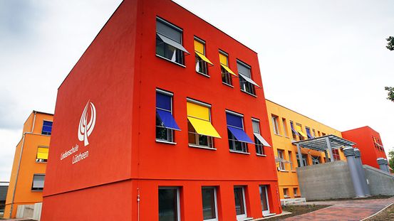 Saniertes Schulzentrum in Lübtheen mit einer bunten Fassade und spezieller Wärmedämmung.