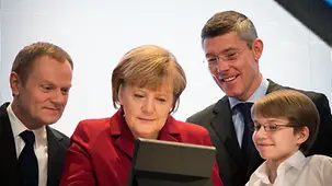 Merkel und Tusk mit dem Jungen Guttbier am Tablet-PC.