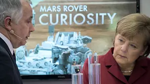 Merkel vor einem Bild des Mars Rover.