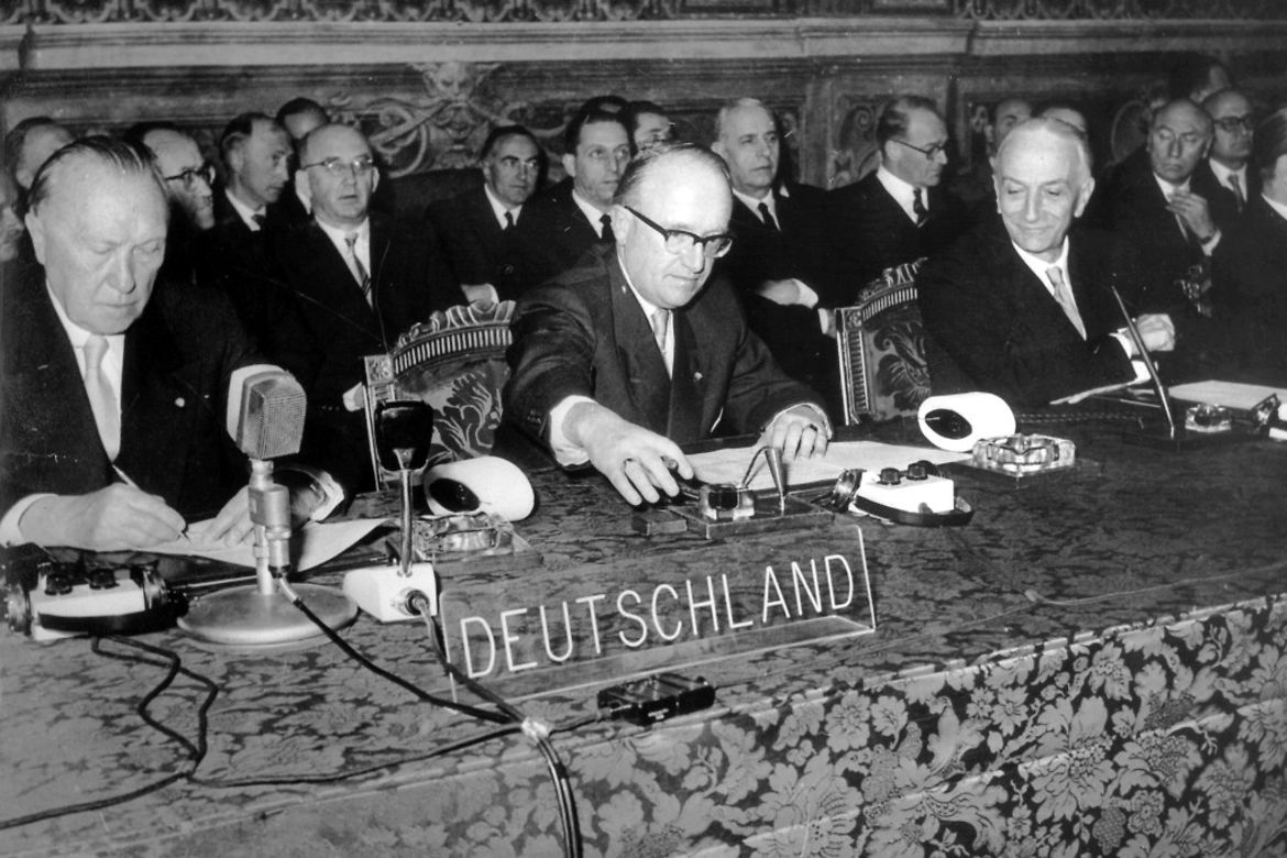 Chancellor Konrad Adenauer (at left) and State Secretary Walter Hallstein (centre) sign the "Treaties of Rome"; at the right sits Italy's Prime Minister Antonio Segni.