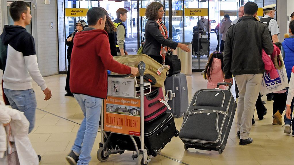 Syrische Flüchtlinge gehen am 04.04.2016 durch die Ankunfthalle B auf dem Flughafen Hannover (Niedersachsen). Es sind die ersten syrischen Flüchtlinge, die legal auf direktem Weg aus der Türkei in die Europäische Union einreisen durften. 32 Menschen …