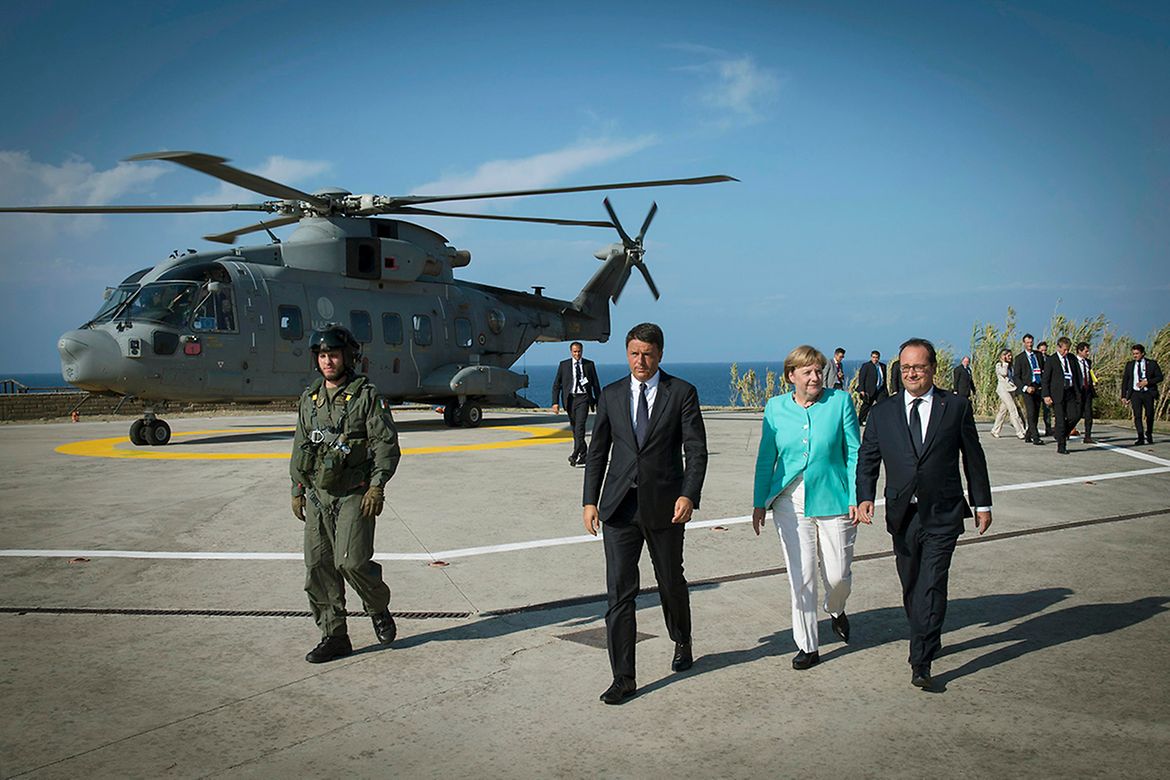 Bundeskanzlerin Angela Merkel geht neben Italiens Ministerpräsident Matteo Renzi und Frankreichs Präsident François Hollande.
