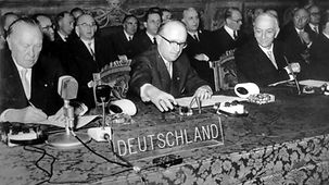 Le chancelier fédéral Konrad Adenauer (à g.) et le secrétaire d’État Walter Hallstein (au milieu) signent les « traités de Rome », à droite le président du Conseil italien Antonio Segni