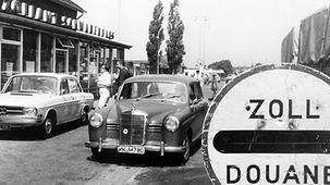 Des véhicules au point de passage de la frontière à Venlo devant un panneau « Douane »