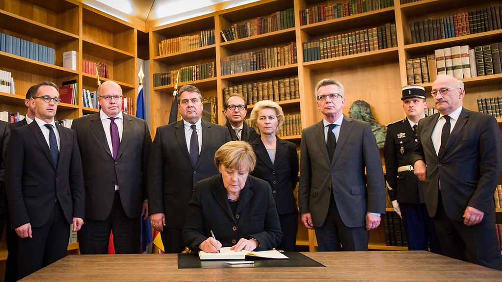 Angela Merkel and her Cabinet ministers sign the book of condolence.
