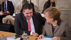 Bundeskanzlerin Angela Merkel und Sigmar Gabriel, Bundesminister für Wirtschaft und Energie, unterhalten sich.