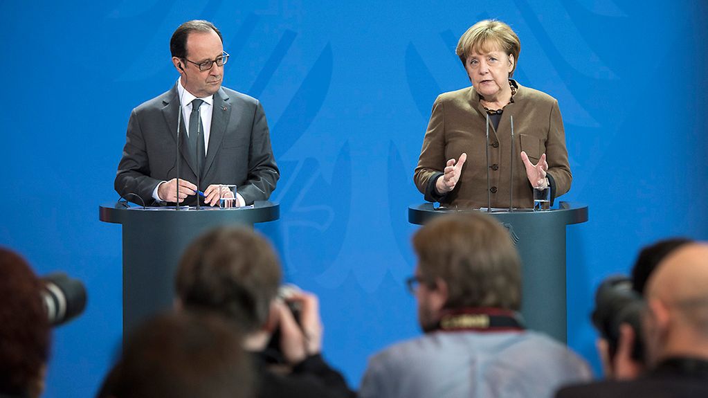 Bundeskanzlerin Angela Merkel spricht neben Frankreichs Präsident François Hollande während einer gemeinsamen Pressekonferenz.