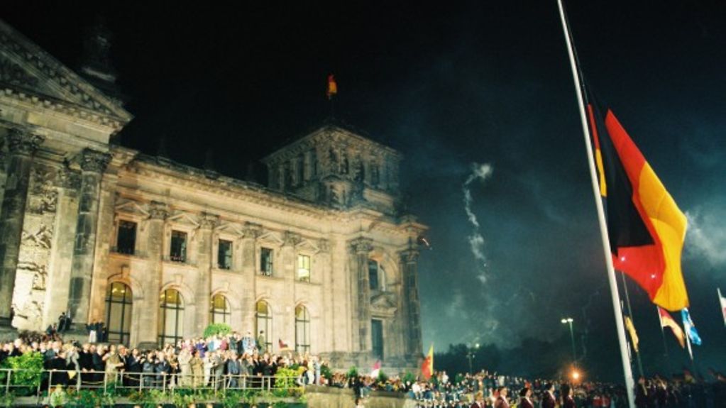 Um 0:00 wird bei der Feier zur Wiedervereinigung vor dem Reichstagsgebäude die schwarz-rot-goldene Bundesflagge gehisst.
