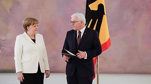 Federal President Frank-Walter Steinmeier presents Chancellor Angela Merkel with her letter of appointment.