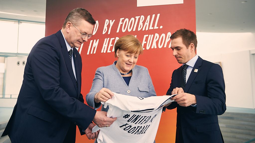Kanzlerin Merkel trifft DFB-Präsident Grindel und den ehemaligen Fußball-Nationalspieler Lahm.