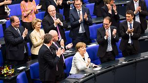 Abgeordnete applaudieren Bundeskanzlerin Angela Merkel nach der Auszählung der Stimmen.