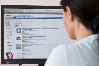 Eine Frau beim online-Einkauf am Computerbildschirm. 