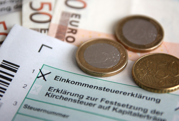Formular zur Einkommensteuererklärung mit Euro-Münzen