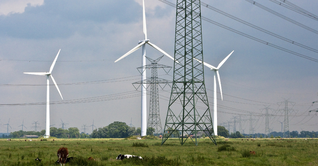 Windkrafträder und Hochspannungsleitung im freien Gelände 