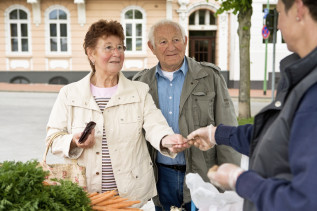 Ein Rentnerpaar beim Einkaufen auf dem Markt.