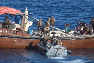 Marinesoldaten in einem Schlauboot überprüfen ein mutmaßliches Piratenboot.