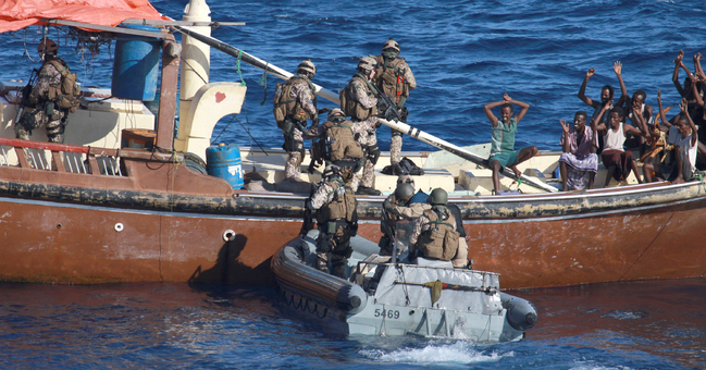 Marinesoldaten in einem Schlauboot überprüfen ein mutmaßliches Piratenboot.