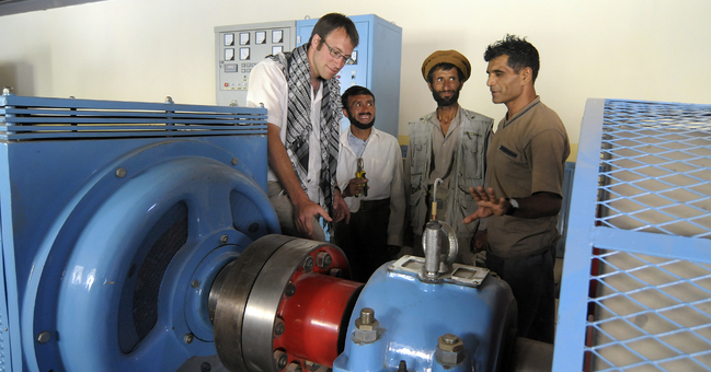 BEntwicklungshelfer erklären eine neue Turbine in einem afghanischen Wasserkraftwerk.