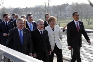 Chancellor Angela Merkel strolls across the footbridge, the Passerelle des deux Rives, with the heads of state and government of NATO member states